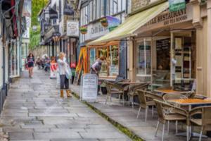 a woman standing on a street with tables and chairs at Stunning Renovation edge of Frome + country views in Frome