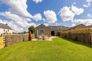 a backyard with a stone fence and a house at Stunning Renovation edge of Frome + country views in Frome