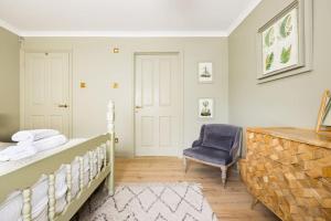 a bedroom with a bed and a blue chair at Stunning Renovation edge of Frome + country views in Frome