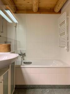a bathroom with a white tub and a sink at Rustico Valgrazia in Molare