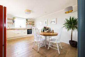 a kitchen with a wooden table and chairs and a table and a plant at Stunning Renovation edge of Frome + country views in Frome