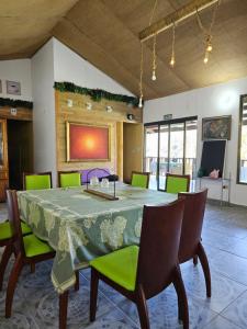 a dining room with a table with green chairs at Eco Horqueta in Boquete