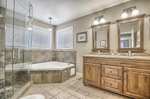 uma casa de banho com uma banheira, 2 lavatórios e um chuveiro em 6 Bedroom Executive Cottage near Innisfil Beach Park em Innisfil