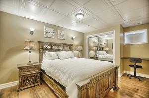 um quarto com uma cama grande e um espelho em 6 Bedroom Executive Cottage near Innisfil Beach Park em Innisfil