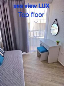 1 dormitorio con escritorio, 1 cama y ventana en BLUE EYES APARTMENTS en Ixia