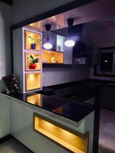 a kitchen with a black counter top with lights at Villa adora in Jodhpur