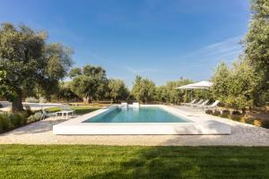 - une piscine dans une cour avec des chaises et des arbres dans l'établissement Masseria Pensato, à Savelletri di Fasano