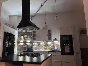 a kitchen with a black counter top and white cabinets at Apartament Starówka in Nowy Sącz