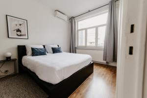 a bedroom with a bed and a large window at Cathedral view apartment in Antwerp