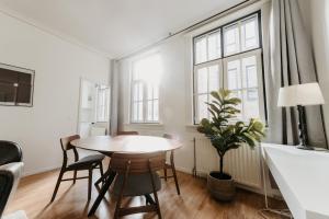 a dining room with a table and chairs and windows at Cathedral view apartment in Antwerp
