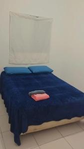 1 cama con edredón azul y almohadas azules en Apartamento Quarto e Cozinha cod 4 Tremembe, en São Paulo