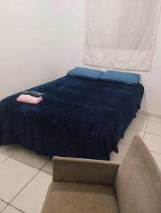 1 cama con manta azul y silla en una habitación en Apartamento Quarto e Cozinha cod 4 Tremembe, en São Paulo