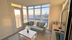 a living room with a couch and a large window at Stunning Luxurious LakeView Condo by CN Tower in Toronto