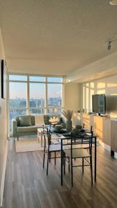 a living room with a table and chairs and a couch at Stunning Luxurious LakeView Condo by CN Tower in Toronto