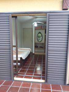 a bedroom with sliding doors with a bed in a room at PARAISO FAMILIAR- Piscina- Pontal do Sul - PR in Pontal do Paraná