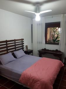 a bedroom with a large bed with a red blanket at PARAISO FAMILIAR- Piscina- Pontal do Sul - PR in Pontal do Paraná