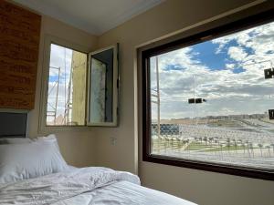 a bedroom with a bed and a large window at PYRAMUSE INN in Cairo