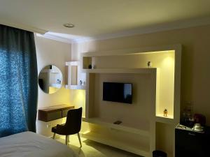 una camera con letto, TV e sedia di PYRAMUSE INN a Il Cairo