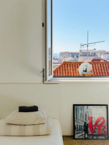 1 dormitorio con ventana y una foto de la ciudad en Love Dubrovnik Hostel, en Dubrovnik