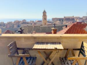 2 sillas y mesa en un balcón con vistas en Love Dubrovnik Hostel, en Dubrovnik