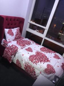 a bedroom with a red bed with a window at Paz Holiday Luxurious Space in Dubai