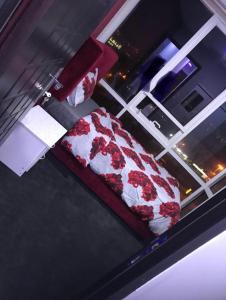 a bed with red and white sheets on a window at Paz Holiday Luxurious Space in Dubai