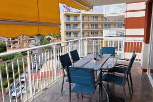 eine Terrasse mit einem Tisch und Stühlen auf dem Balkon in der Unterkunft Apartamento dos habitaciones, frente a la playa, in Benicàssim