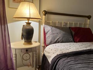 una lámpara en una mesa lateral junto a una cama en Alonaki House en Amfiklia
