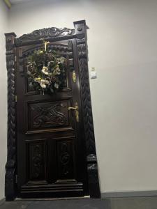 a large wooden door with christmas decorations on it at Apartament Starówka in Nowy Sącz