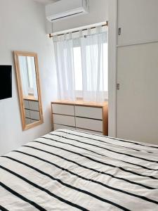 1 dormitorio con cama, espejo y ventana en Apartamento en Belgrano en Buenos Aires