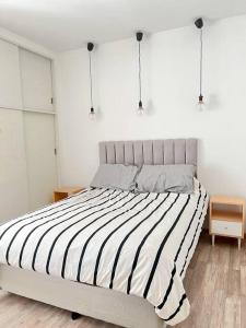 1 dormitorio con 1 cama grande con rayas blancas y negras en Apartamento en Belgrano en Buenos Aires
