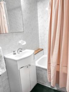 Baño blanco con lavabo y cortina de ducha en Apartamento en Belgrano en Buenos Aires
