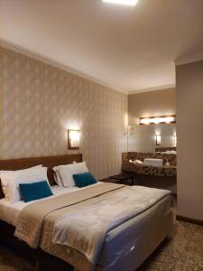 a bedroom with a large bed with two blue pillows at Hotel Pousada Santa Rita in Ribeirão Preto