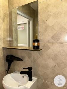 een badkamer met een wastafel en een spiegel bij Prishtina Center Apartment 3 in Pristina