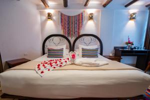 um quarto com uma cama grande e um bicho de peluche. em Vilas Insight Hotel Machupicchu em Machu Picchu