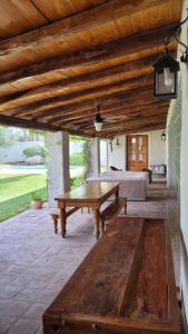eine Terrasse mit einem Holztisch und einem Bett in der Unterkunft Casa Maca in Mendoza