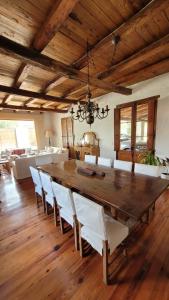 a dining room with a large wooden table and white chairs at Casa Maca in Mendoza