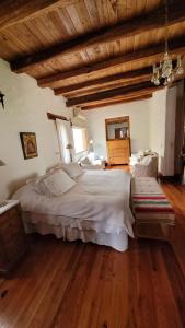 a bedroom with a large bed and wooden floors at Casa Maca in Mendoza