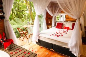 a bedroom with a bed with red roses on it at Boutique Bangalôs De São Chico in São Francisco de Paula