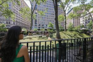 a woman standing in front of a fountain in a city at The Evelyn NoMad in New York