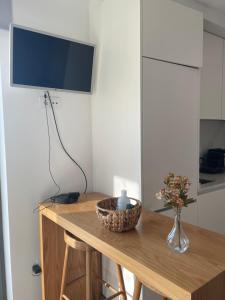a table with a vase of flowers and a television at Foz Douro in Porto