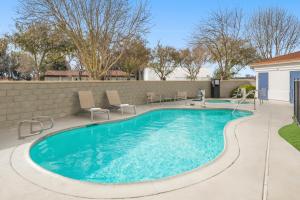 una piscina en un patio con sillas alrededor en SpringHill Suites by Marriott Modesto, en Modesto