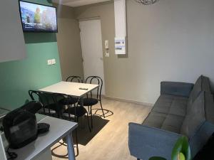 un soggiorno con divano e tavolo di Appartement 2 - Hyper centre - 1 à 4 personnes a Douai