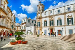 a city street with a clock tower in the middle at Le Plaisir Luxury Room con vasca idromassaggio in Martina Franca