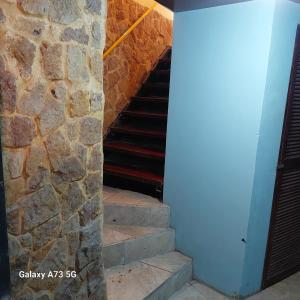 a set of stairs with a stone wall at Costa Linda Art Hostel in Manuel Antonio