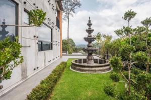 a garden with a fountain in front of a building at La Fábrica #5 Saint Gobain in Valle de Bravo