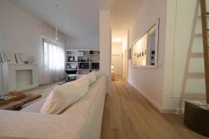 een woonkamer met een witte bank en houten vloeren bij 12 living in Ancona
