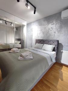 a bedroom with a large bed with mirrors on the wall at MoonZE apartman, free parking in Novi Grad