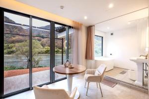 uma sala de estar com uma mesa e cadeiras e uma casa de banho em R;MOGAMI - Vacation STAY 25489v 