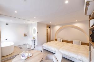 ein Schlafzimmer mit einem großen Bett, einer Badewanne und einem Waschbecken in der Unterkunft R;MOGAMI - Vacation STAY 25489v 